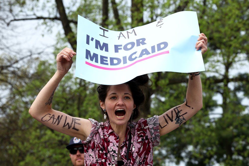 A Medicaid recipient protests funding cuts outside the U.S. Supreme Court in April.