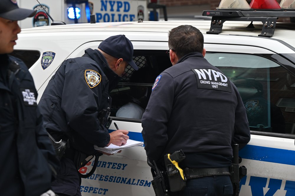 NYPD officers take someone into custody in Queens on April 27, 2025.
