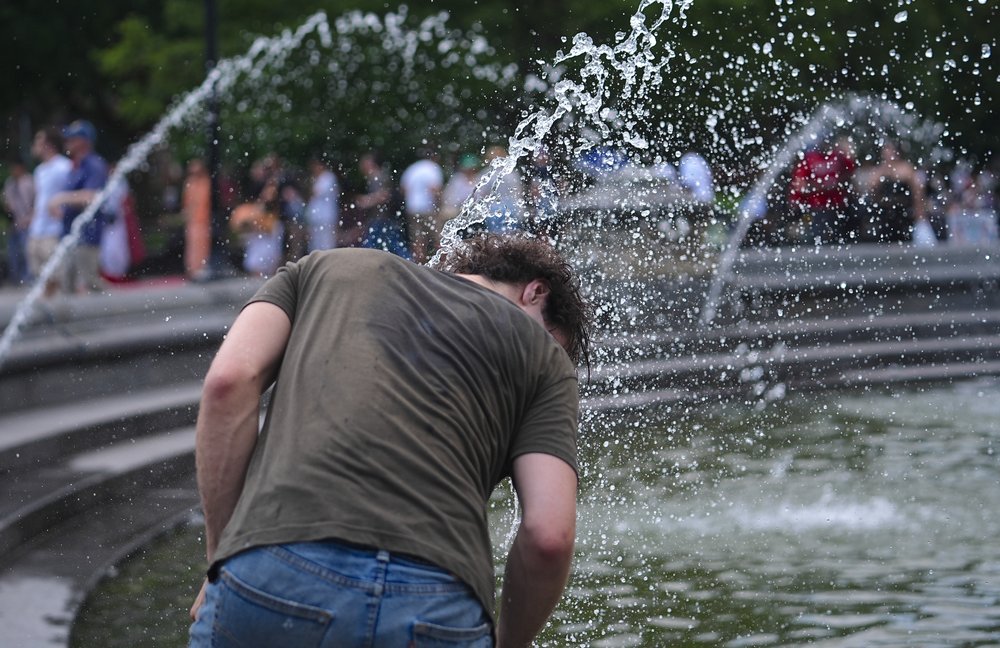 A man tries to cool off during the first summer heat wave of the season