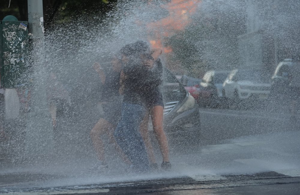 People play in a fire hydrant.