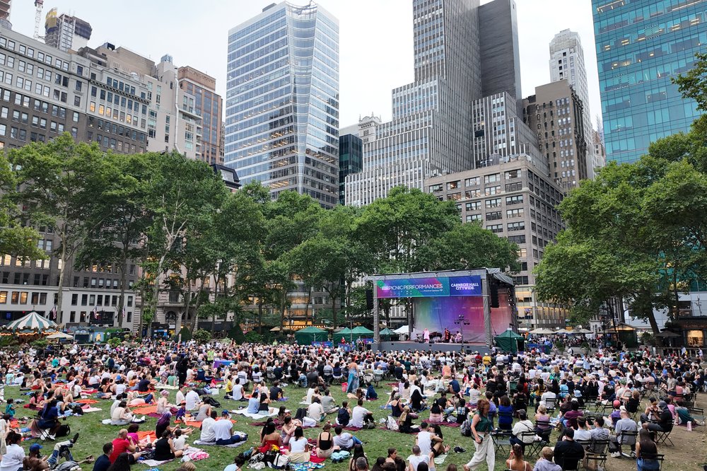 A group of people sit in Bryant Park in New York City.