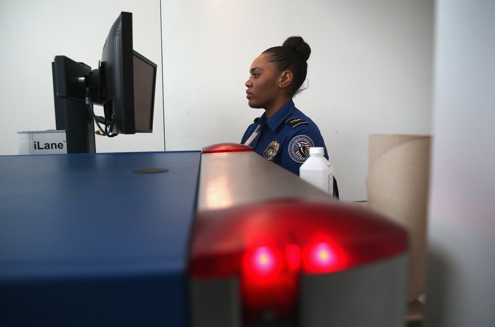 A TSA agent watches xray monitors while screening luggage at a special TSA Pre-check lane at Terminal C of the LaGuardia Airport on Jan. 27, 2014 in New York City.