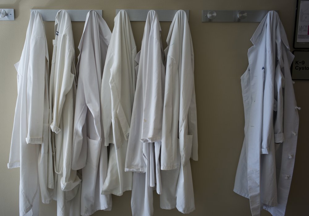White doctor's jackets hang on a wall rack of the New York-Presbyterian Weill Cornell Medical Center hospital in Manhattan.