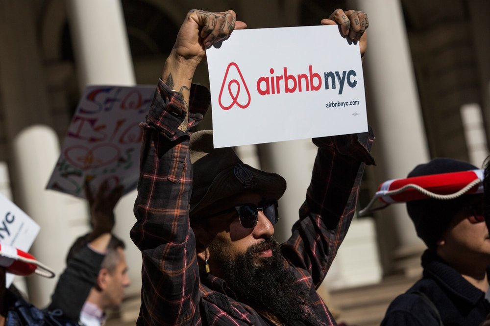 guy holding airbnb sign