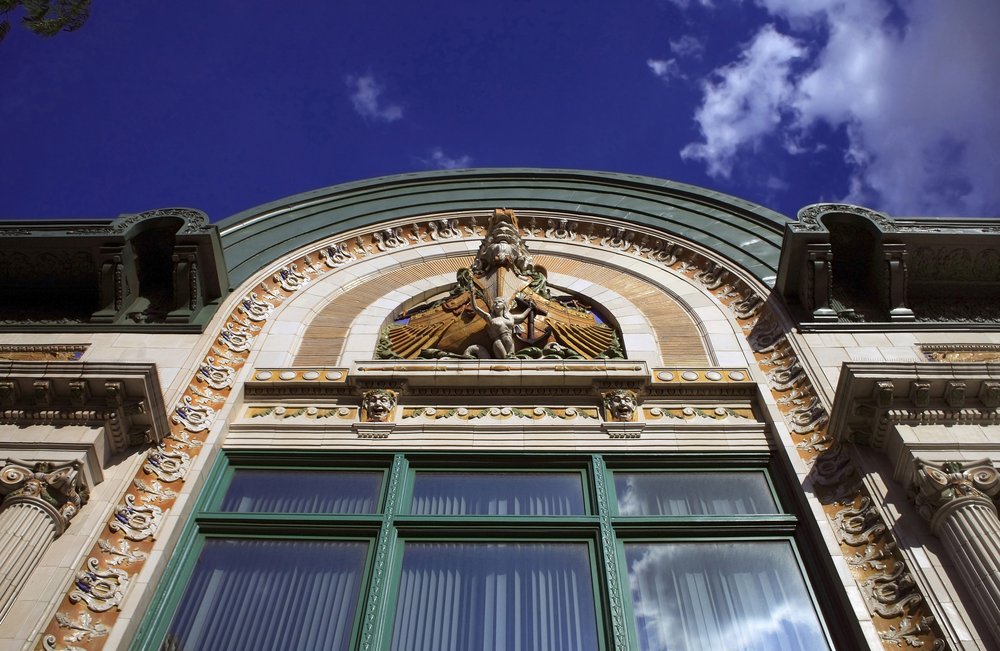 The exterior showing the facade of the Audubon Ballroom, an ornate beige building with gold and turquoise details.