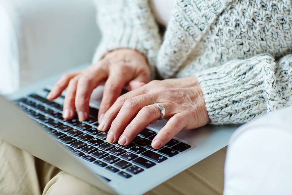 An older woman uses a computer.