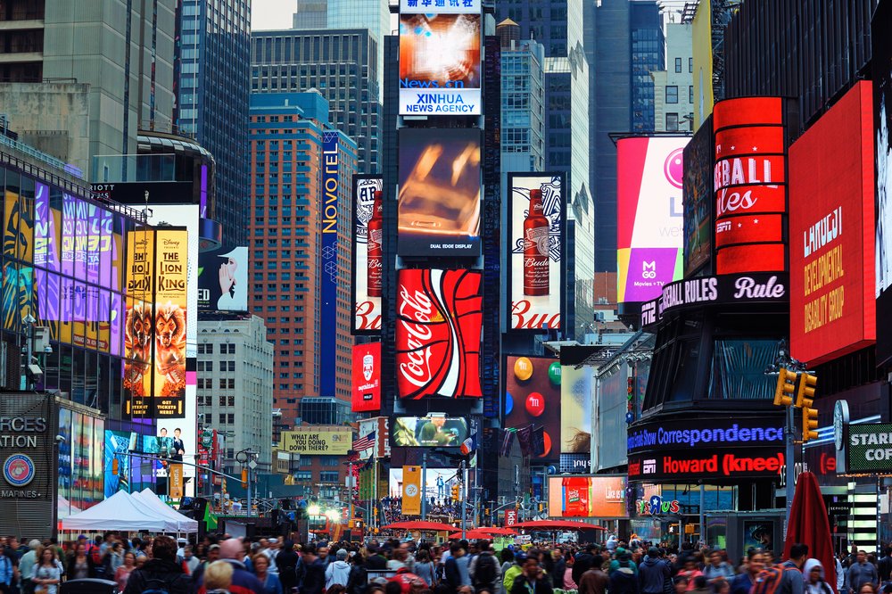 A series of skyscrapers and pedestrians in Times Square.