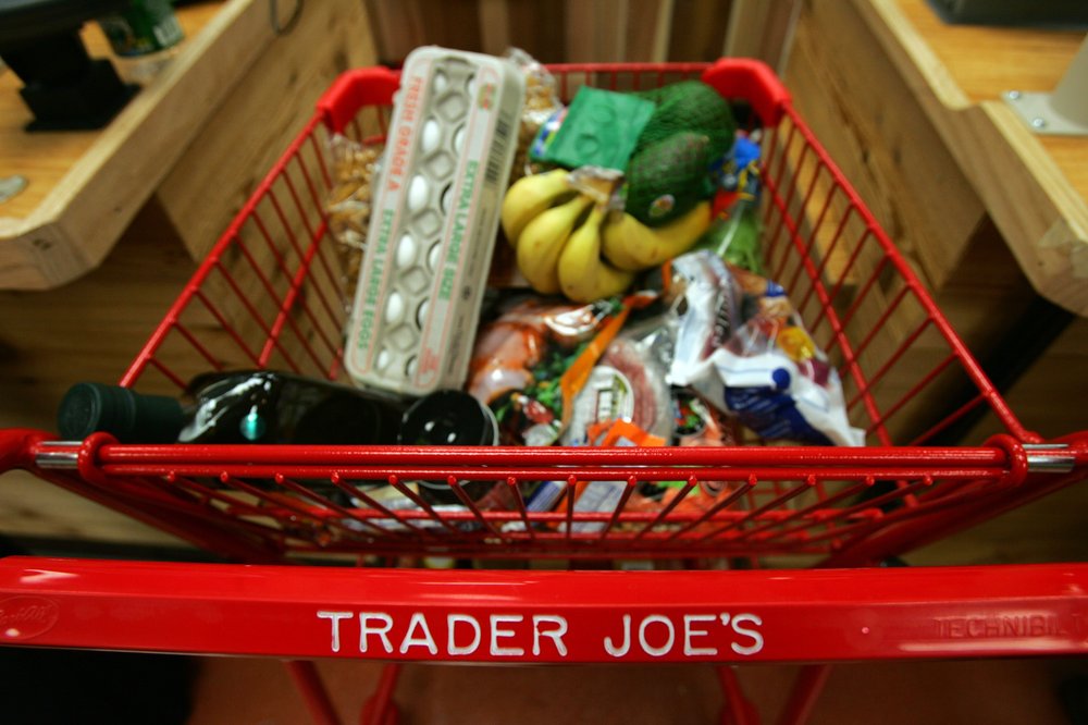 A Trader Joe's shopping cart full of groceries.