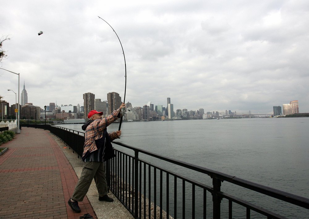 An angler casts into the East River from Manhattan.