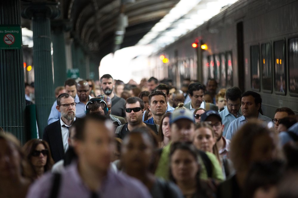 A shoulder-to-shoulder crowd of passengers disembark from a New Jersey Transit train in Hoboken in 2017.