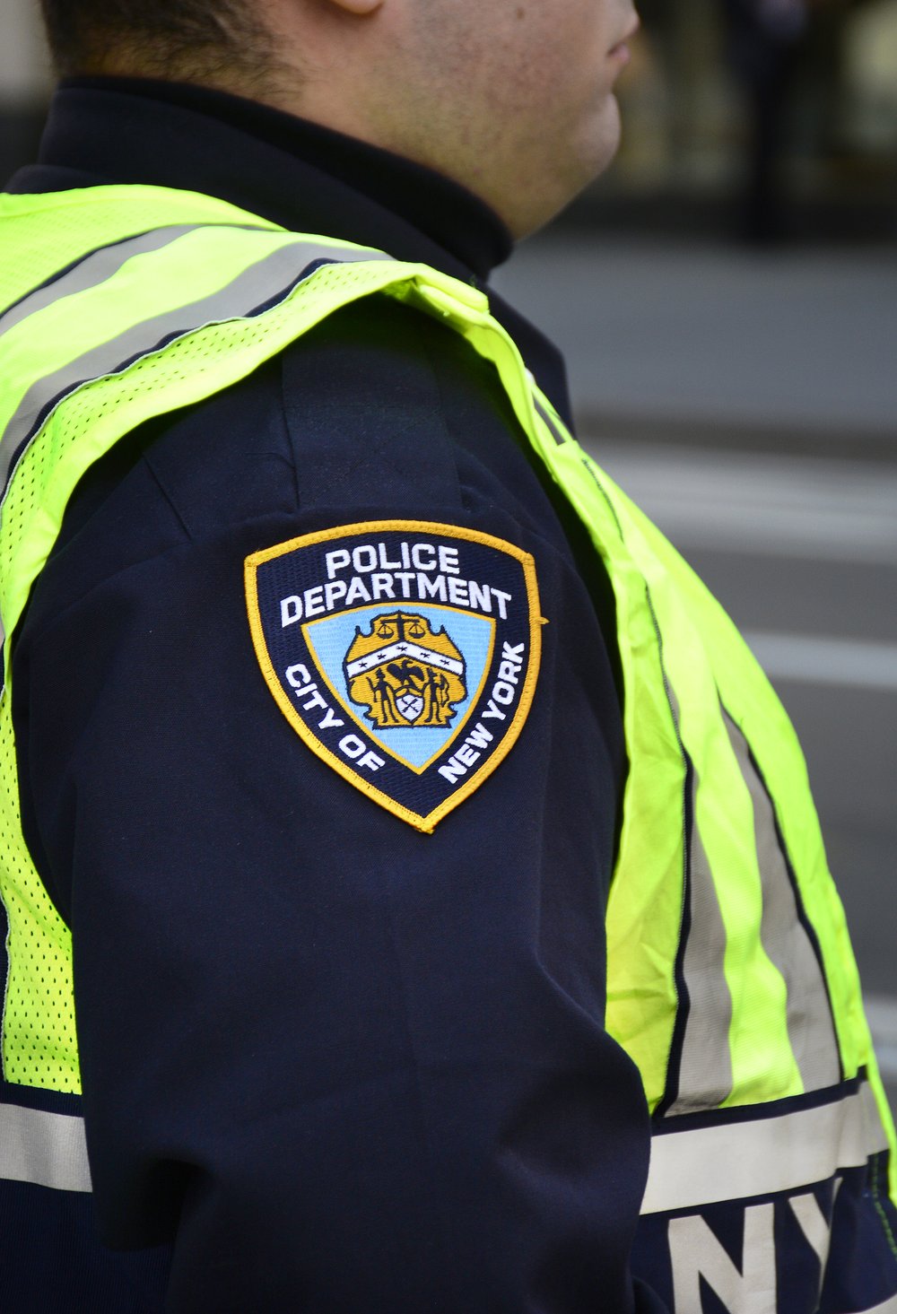 A New York City police officer stands at a busy street corner in New York, New York.