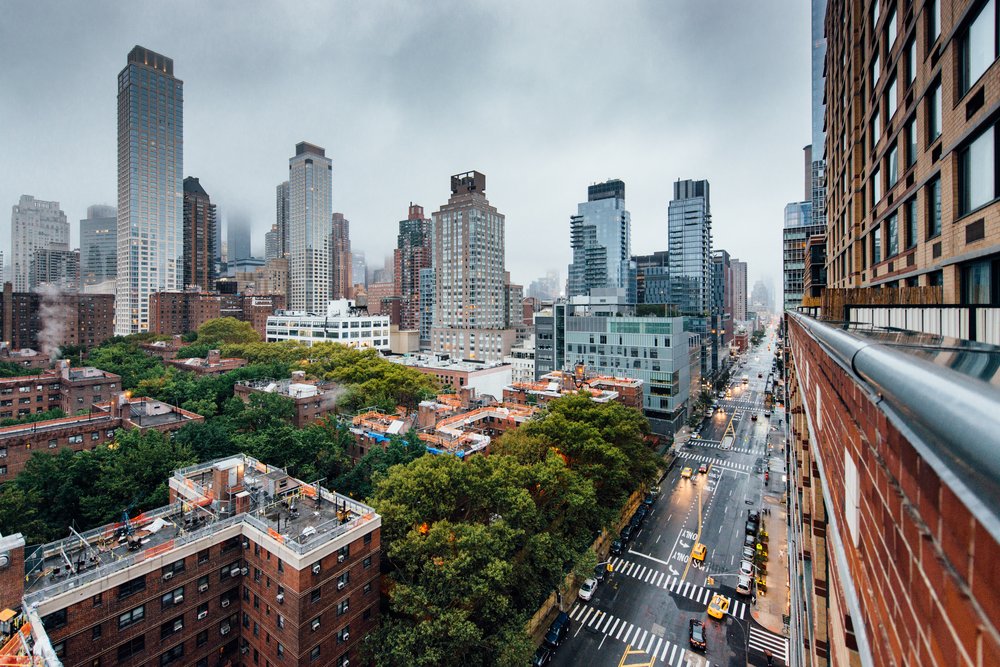 A photo of a New York City street on a gray, rainy day, taken from the window of a high rise.