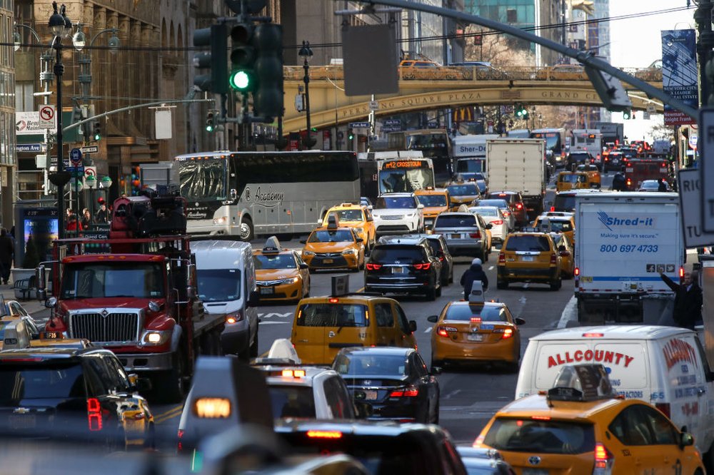 Dozens of vehicles, including yellow cabs, trucks, vans and buses, sit in traffic near 42nd Street.