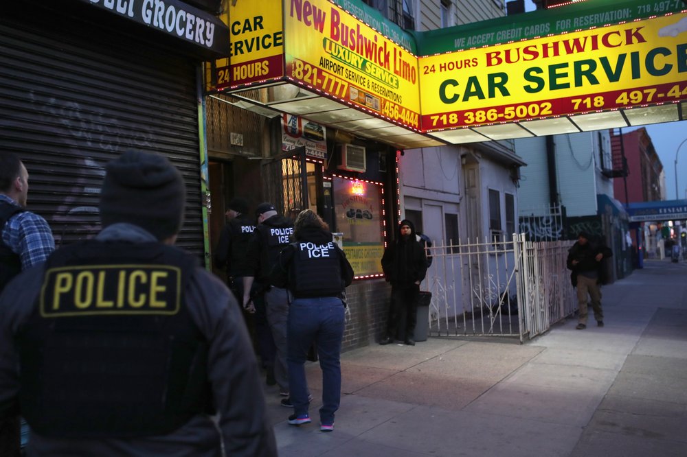 ICE agents walk into a Bushwick car service office.