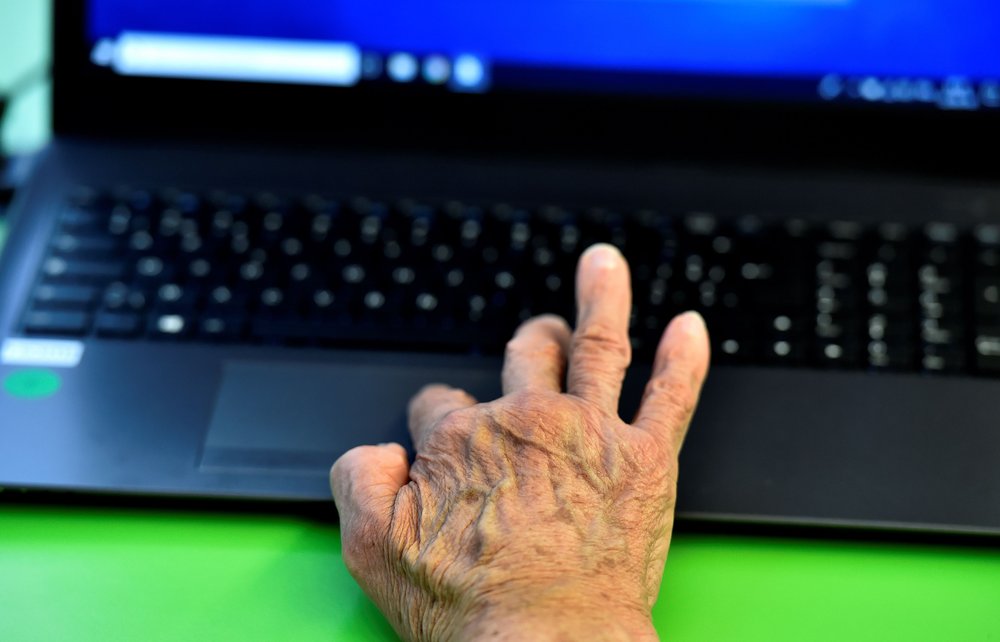 An elderly person uses a computer during a computer workshop.