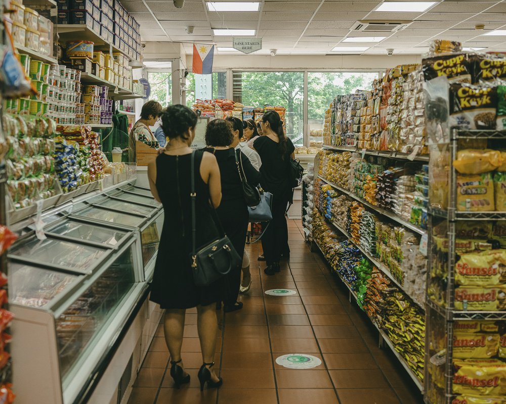 Customers stand in a grocery store checkout line.