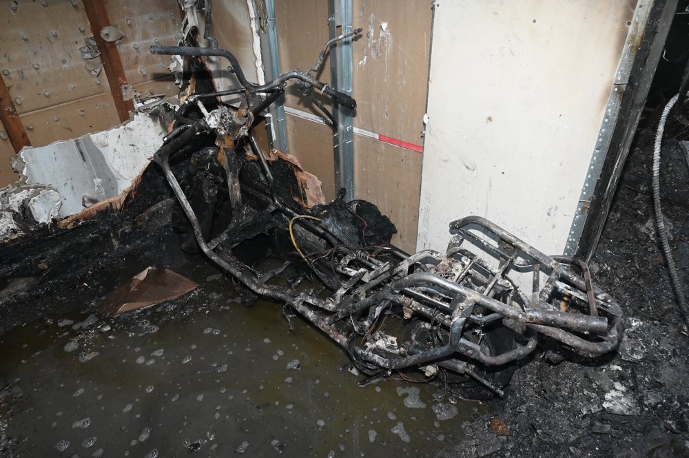 The remains of a lithium-ion battery-powered e-bike lie near the restaurant bathroom where it blocked an exit, trapping a 76-year-old woman during a July 4 fire in Queens.