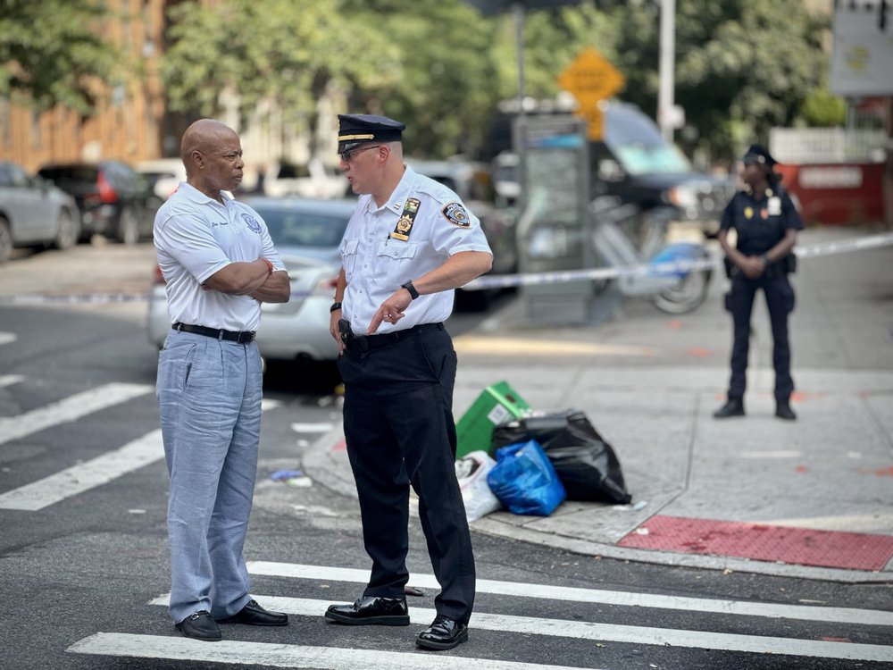 Mayor Eric Adams speaks with NYPD leadership at the scene of Sunday’s mass shooting in Crown Heights.
