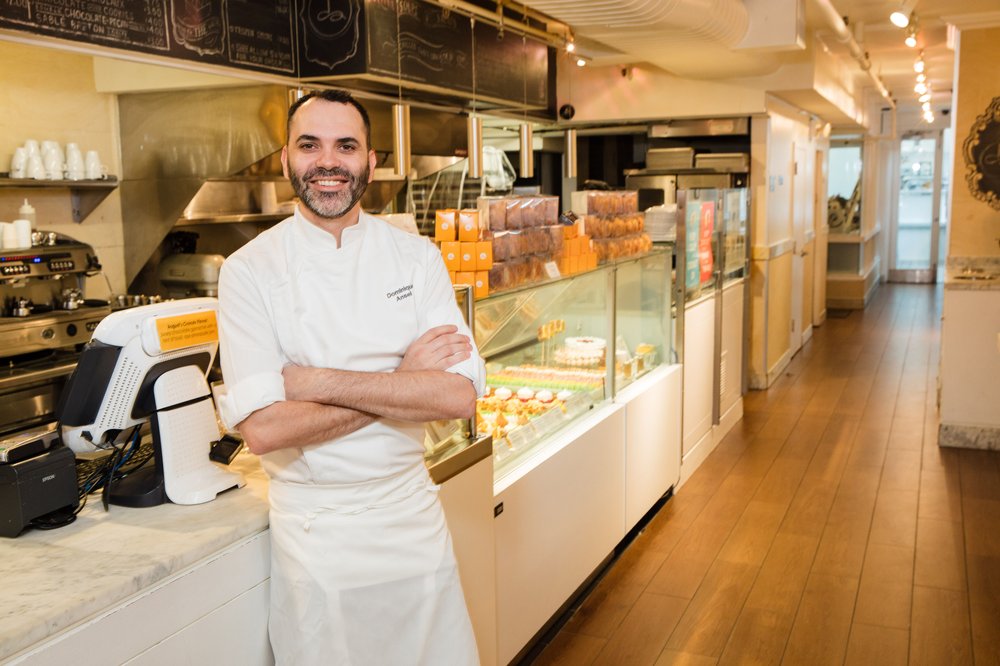 A chef wearing his apron is pictured in his bakery.