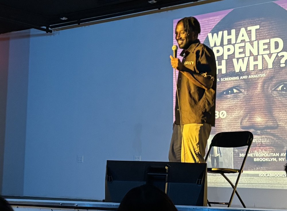 A man stands on stage holding a microphone.