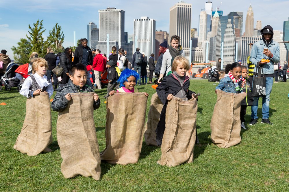 Five children participate in a sack race.