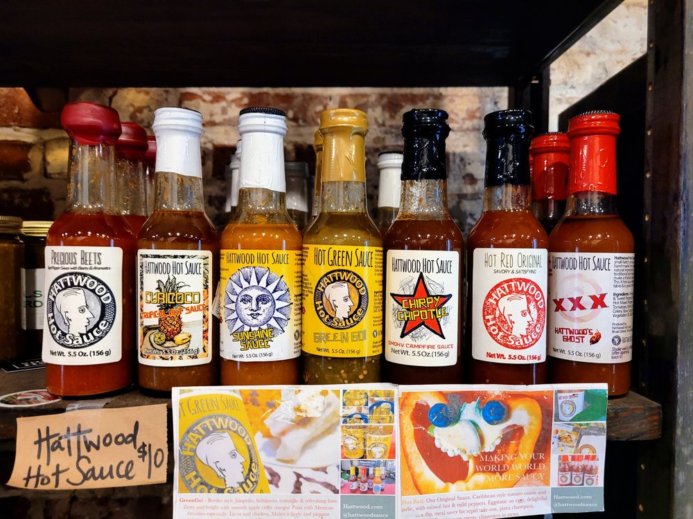 A collection of glass bottles with hot sauces.