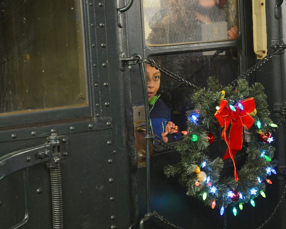 Child looks out the window of a vintage train car