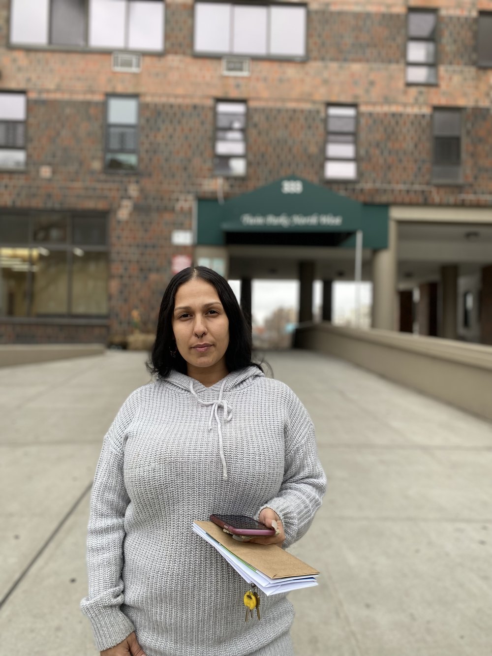 Jeannine Torres, a former resident of Twin Parks high-rise, stands outside of the building she once called home