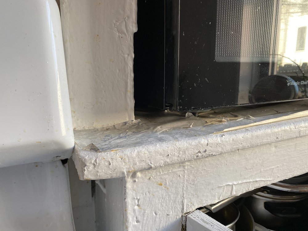 Deteriorating paint on a kitchen cabinet