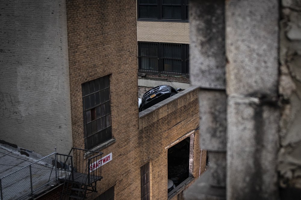 A Mercedes falling into a collapsed parking garage.