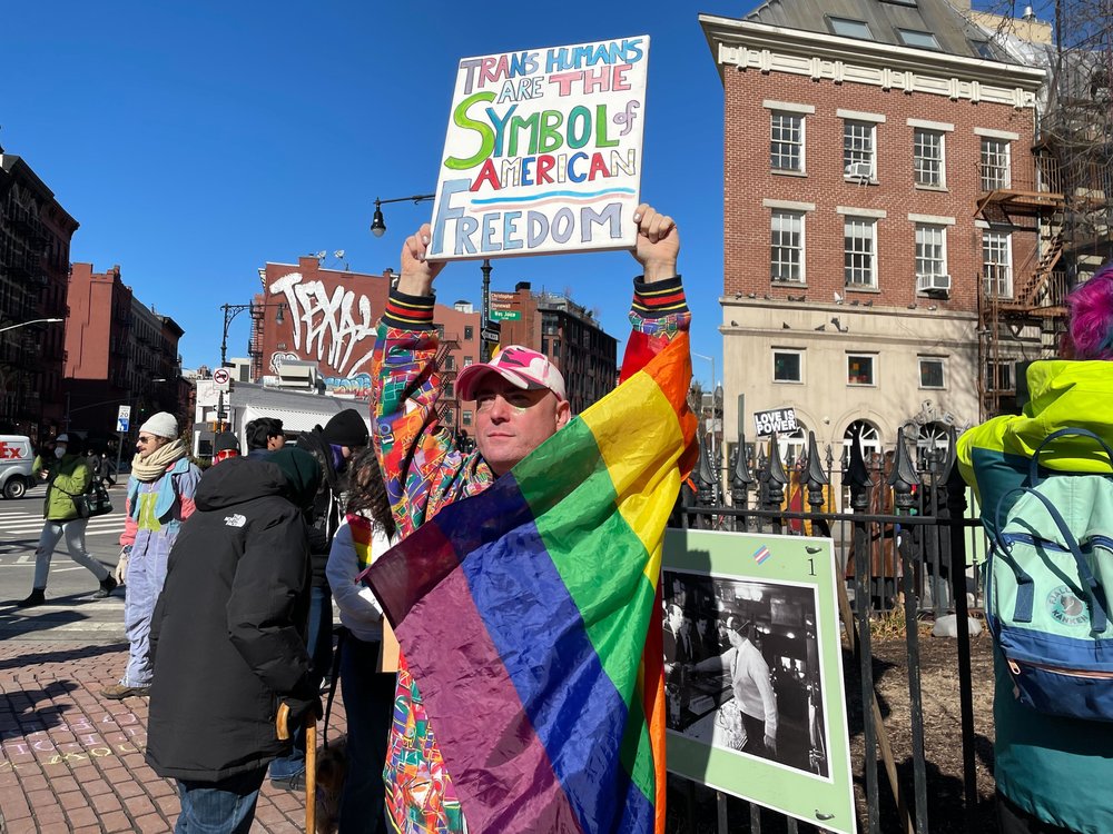 A protester holds up a sign at the Stonewall National Monument in Greenwich Village on Feb. 14, 2025.