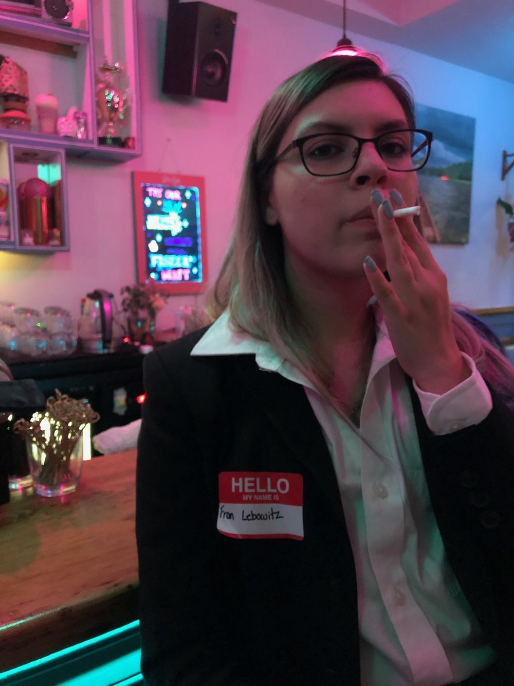 A woman holds a cigarette close to her mouth.