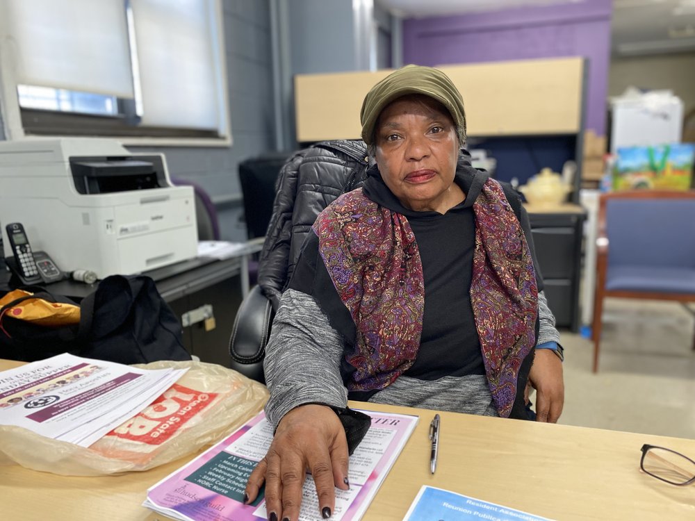 Darlene Waters, the Chelsea-Elliott Houses Tenant Association President, sits behind her desk that contains piles of annoucements.