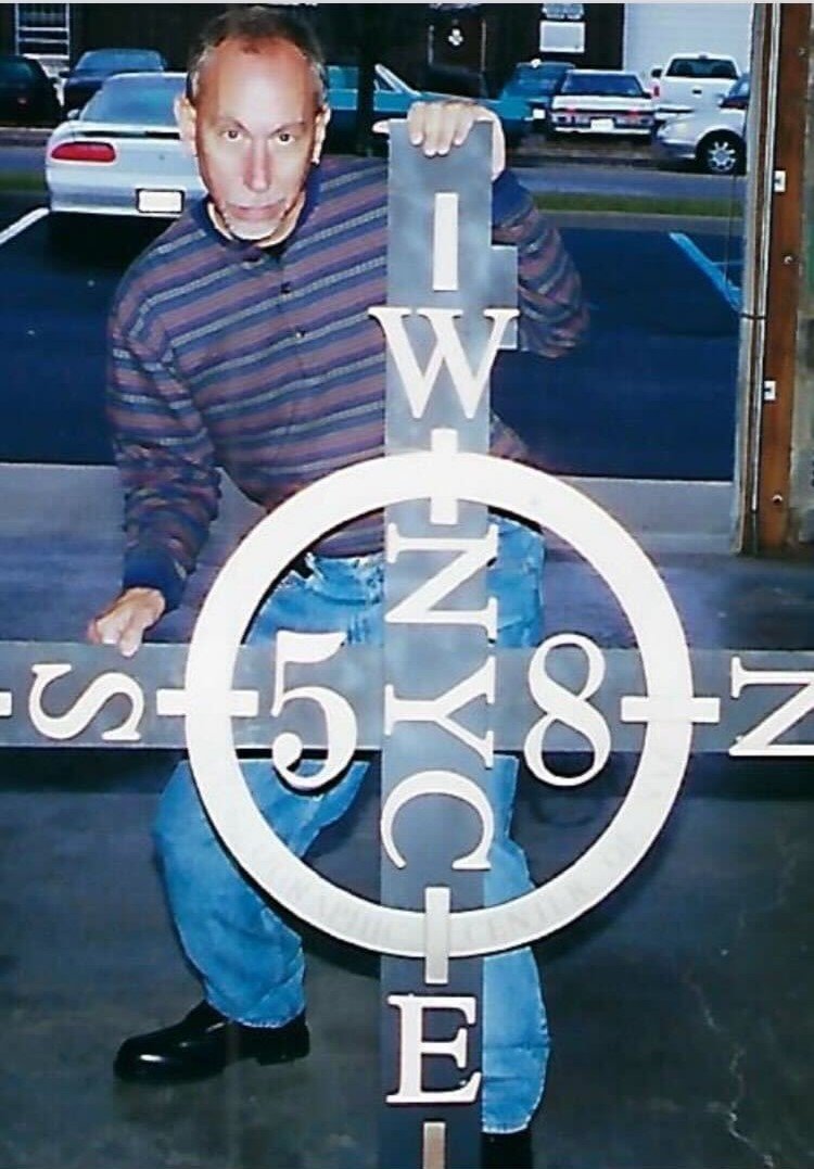 A man is seen holding a cross-shaped marker.
