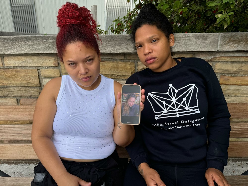 Oriana Martinez (left) and her sister Jairobis Martinez (right) hold up a photo of their mother Sandra Martinez on July 31, 2024.
