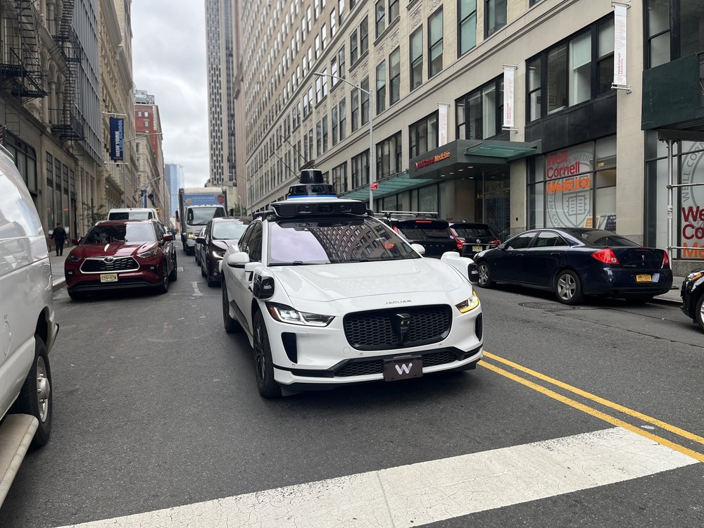A waymo car rolling on a Manhattan street.