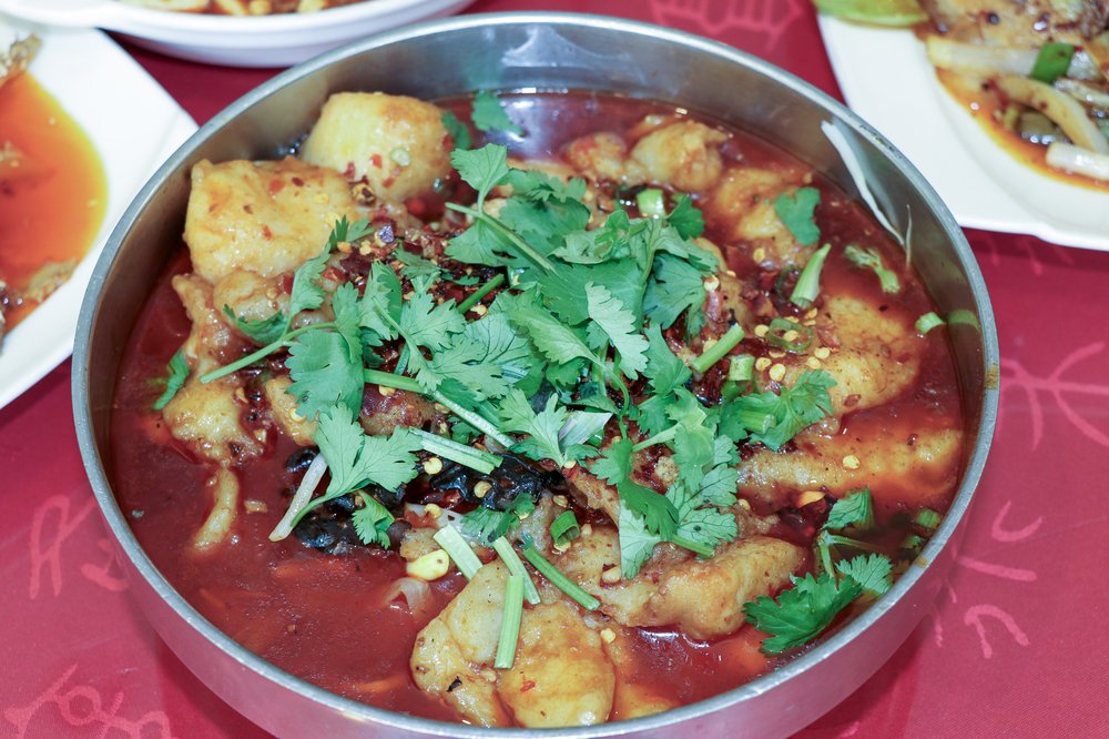 A bowl of food with a green garnish on top.