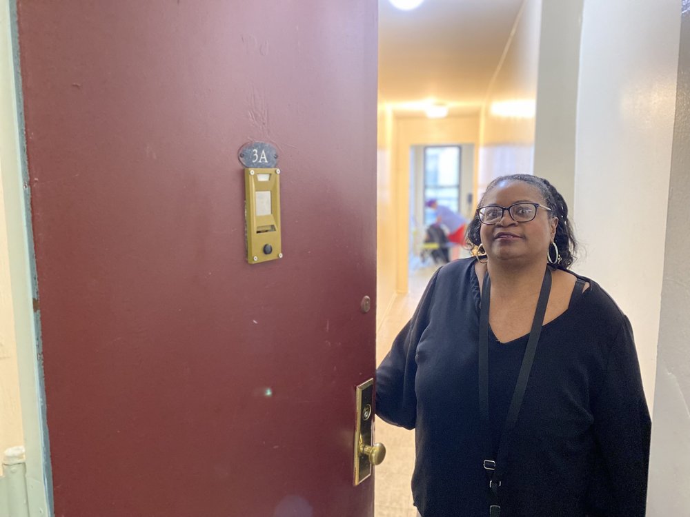 Baird opens the red door of her new apartment in Sunset Park, Brooklyn.