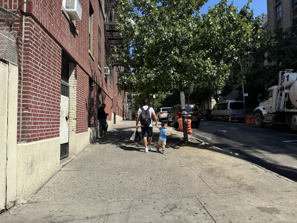A photo of a father walking his toddler outside the former site of the Divino Niño Day Care Center