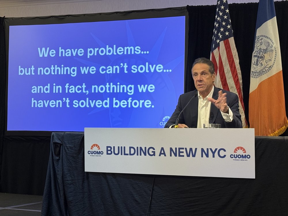 Cuomo delivers a Power Point presentation.
