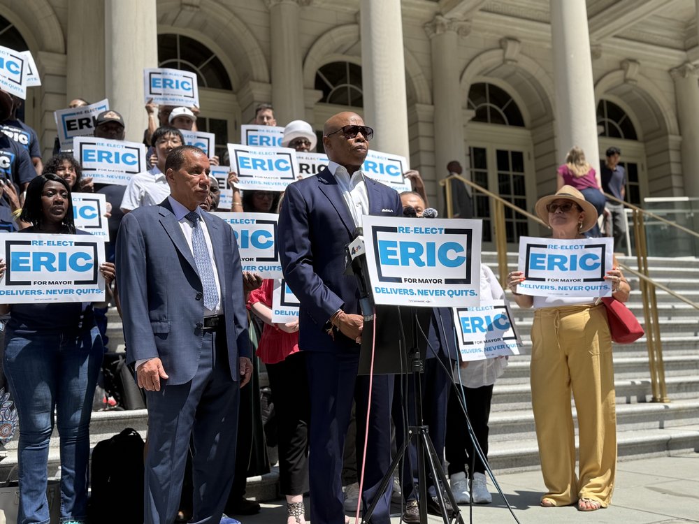 Gov. David Paterson stands behind Mayor Eric Adams on the steps of City Hall.