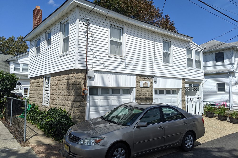 A white home with an attached garage that contains an apartment.