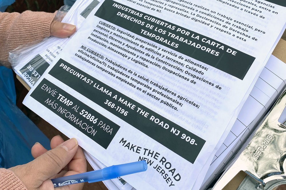 A fact sheet about New Jersey's Temp Workers Bill of Rights, held by a labor rights organizer.