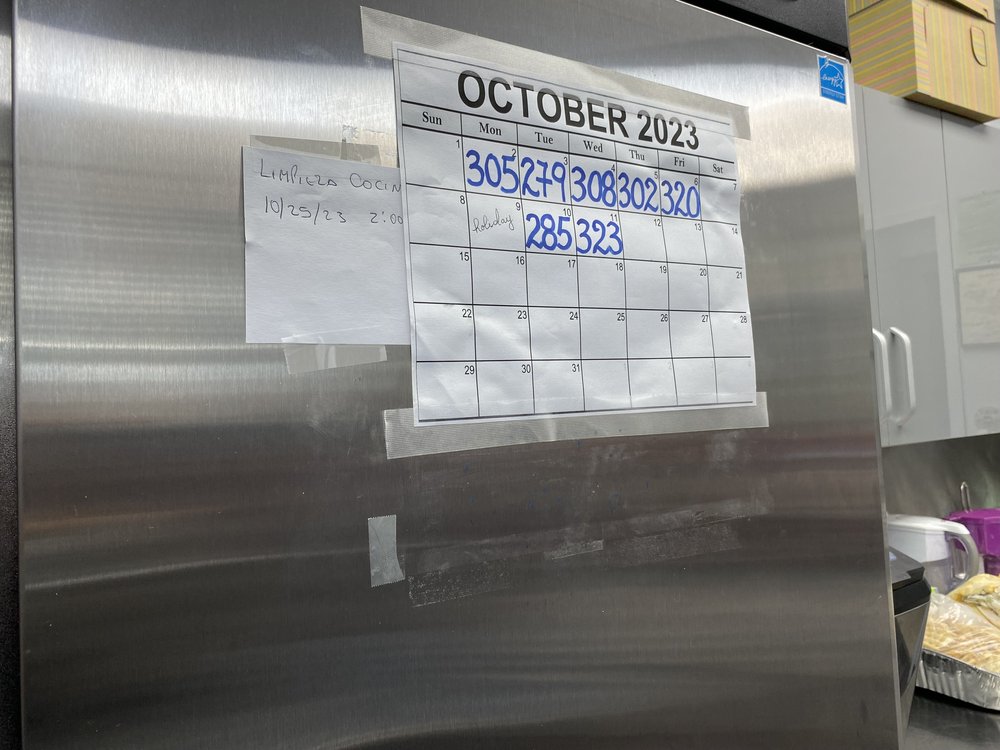 A calendar on the fridge shows how many hot meals were served in October at the Salvation Army Queens Temple Corps in Jackson Heights.