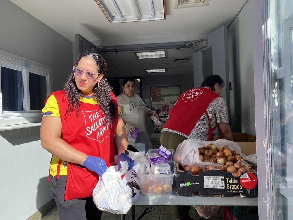 Volunteers hand out bags of groceries on Thursday, Oct. 12, that included bagged beans, tuna, onions, raisins and milk. On Thursday, residents waited hours before the doors opened and volunteers distributed at least 188 grocery bags.