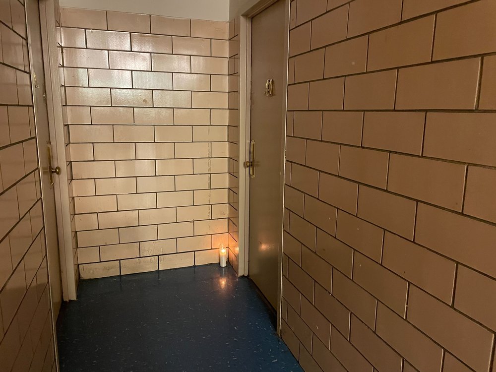 A photo of a candle in front of Rivera’s longtime apartment in the Mill Brook Houses.