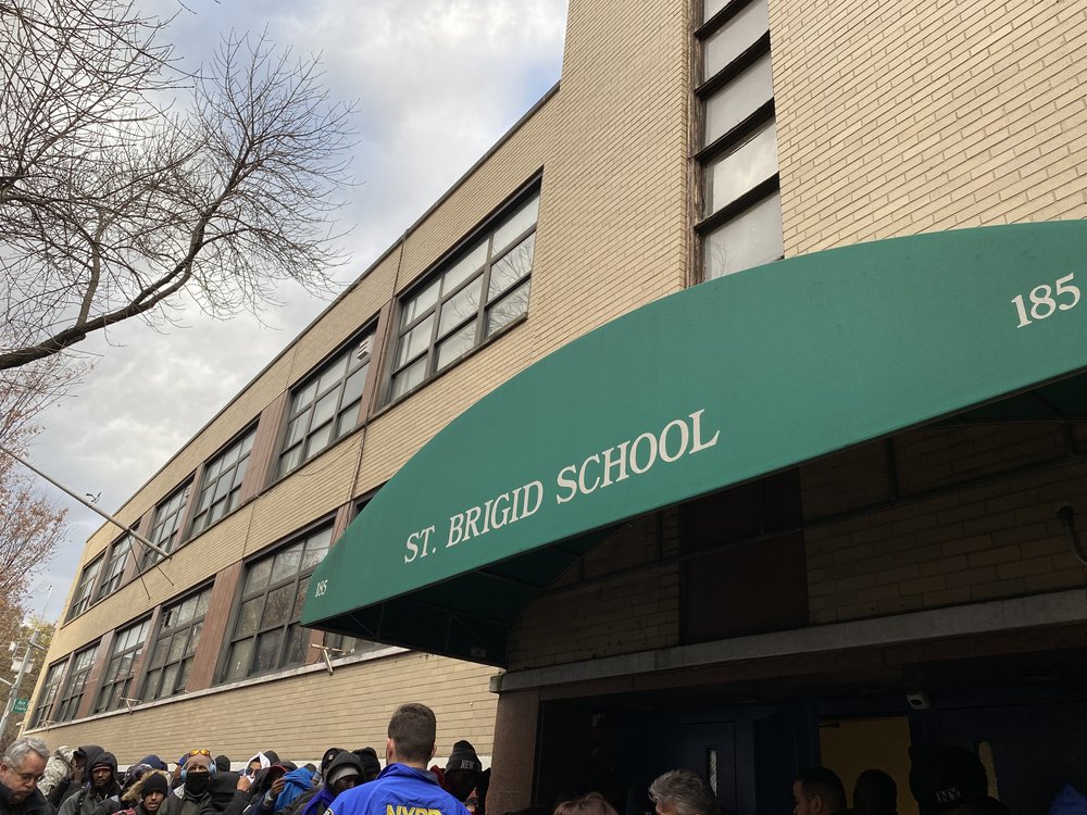 The green awning of St. Brigids, a former school in the East Village where migrants are lining up to get shelter placement.