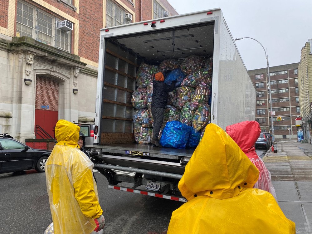 Containers are sorted according to distributors who arrive in trucks to pick up bottles and cans of various brands.