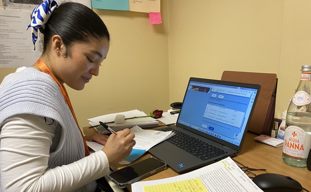 Sheyna Molina, a benefits specialist with the Center for Family life in Sunset Park signs her clients up for IDNYC appointments.
