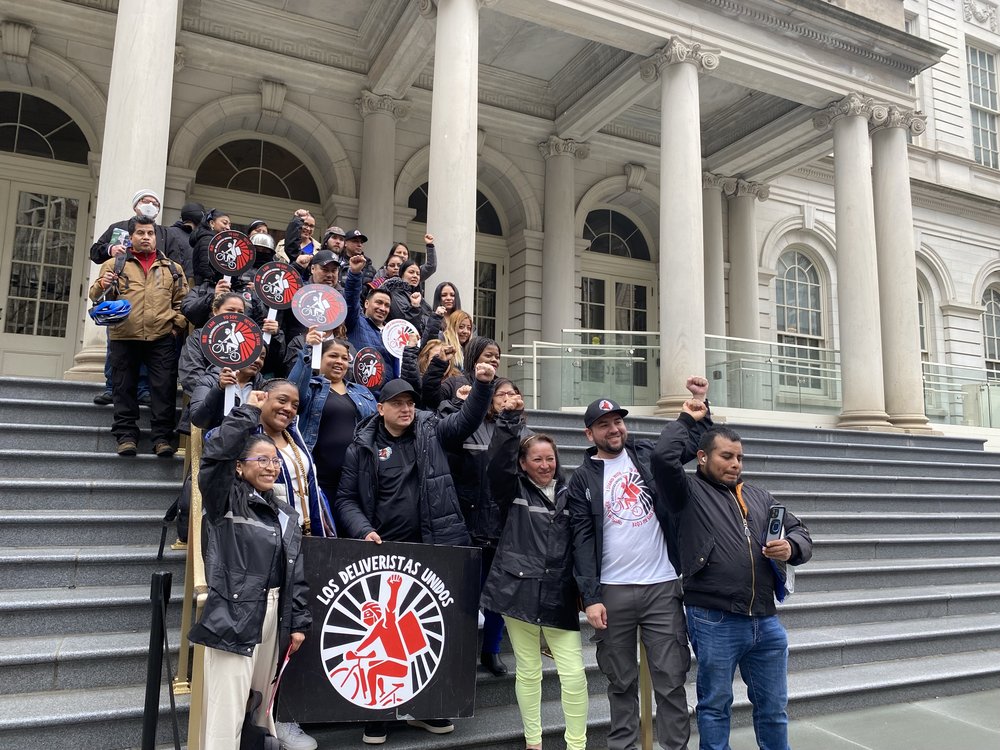 People celebrate on the steps of City Hall.